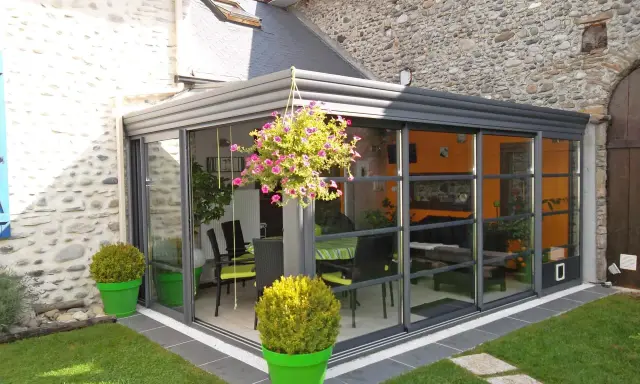 Veranda moderne avec vue sur jardin. Pensez à la taxe d'aménagement veranda pour ce projet d'agrandissement.