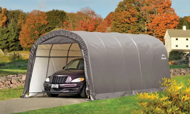 Voiture violette garée sous un carport démontable sans autorisation, dans un paysage d'automne.