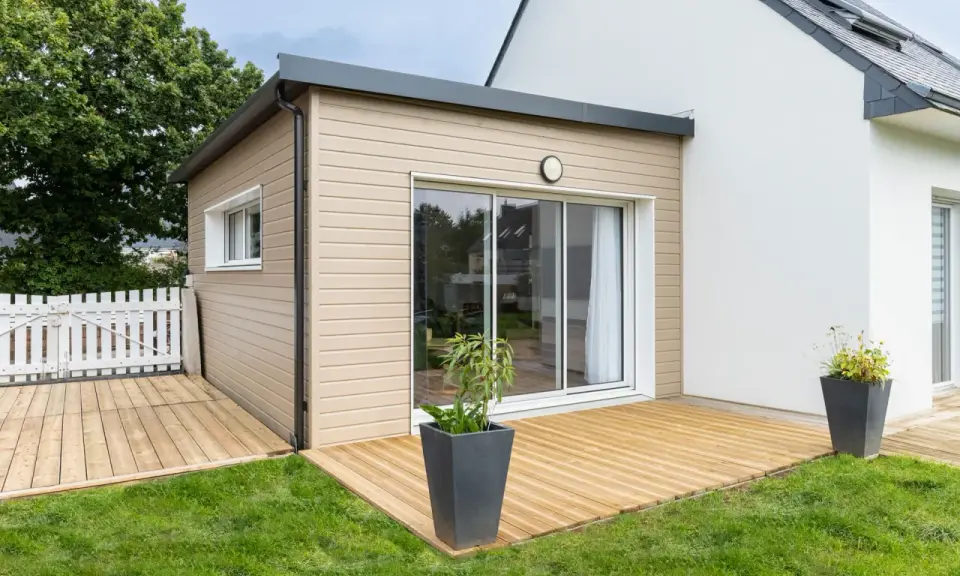 Une extension bois moderne avec terrasse en bois, créant un espace de vie extérieur agréable.