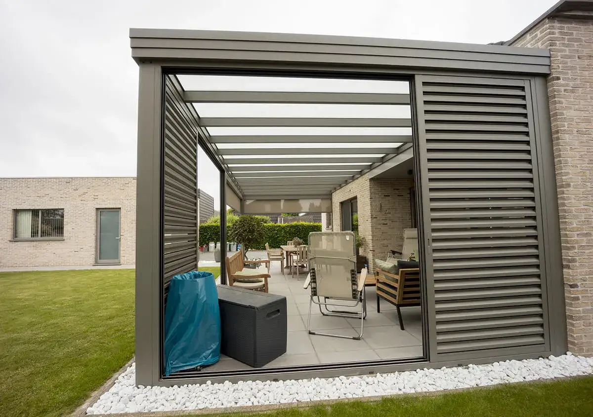 Un pr&eacute;au semi-ferm&eacute; avec mobilier de jardin, une table et des chaises, pr&ecirc;t pour des moments de d&eacute;tente en ext&eacute;rieur.