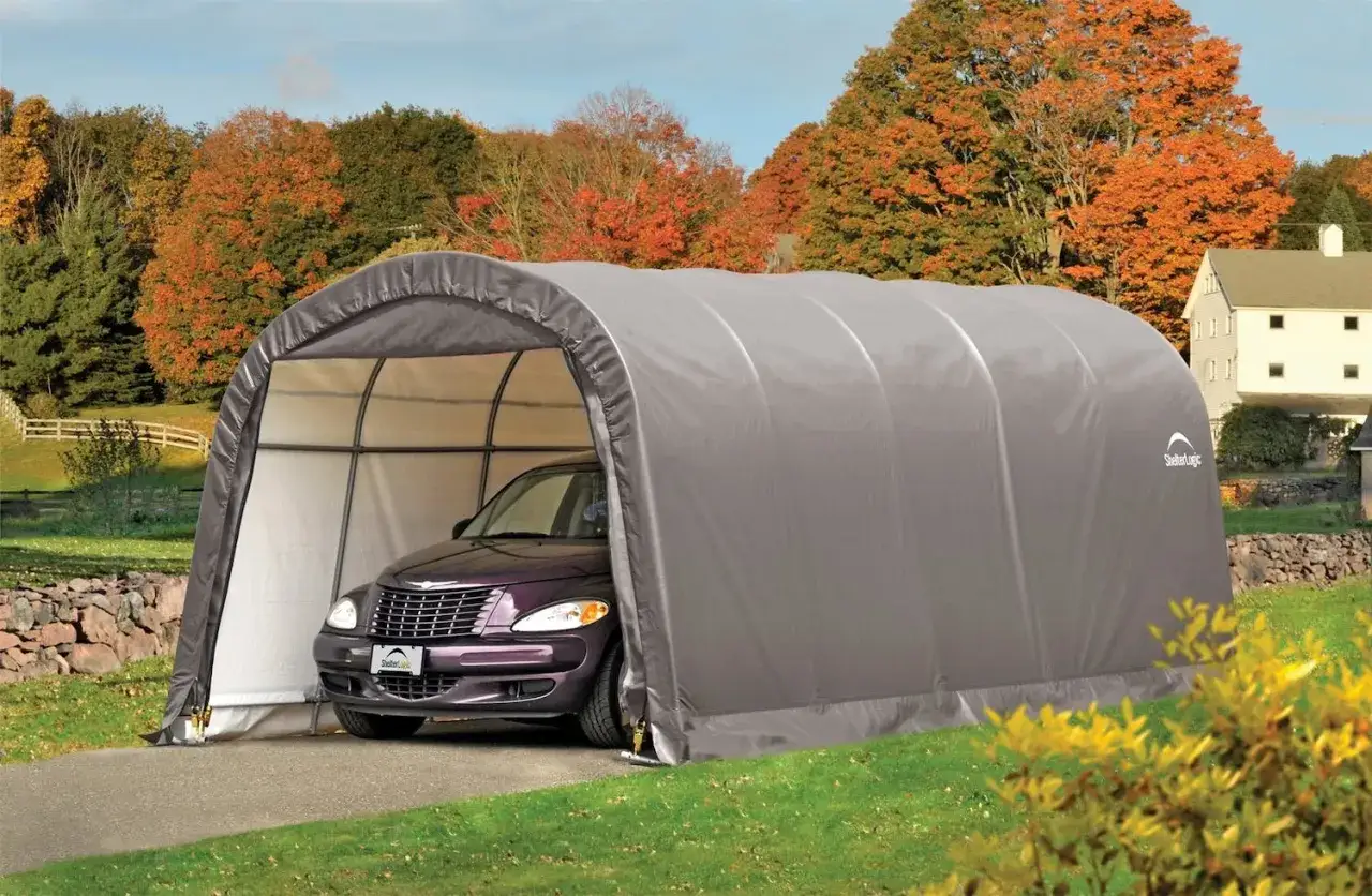 Un carport d&eacute;montable sans autorisation prot&egrave;ge une voiture violette dans un paysage automnal.