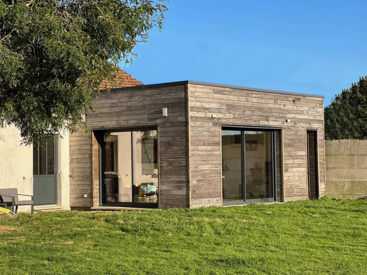 Extension moderne en bois avec grandes baies vitrées, un projet de plan extension maison 20m2.