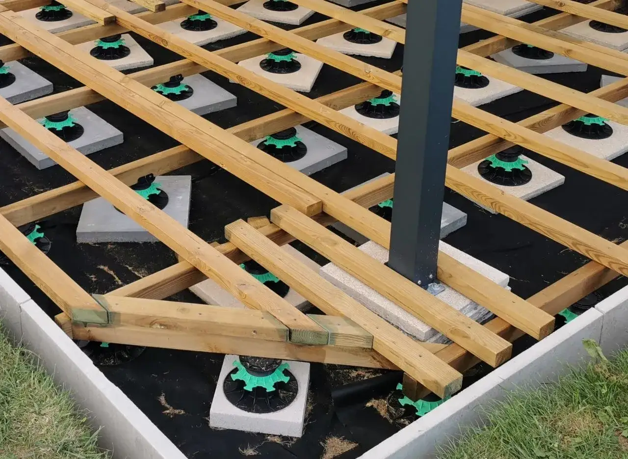 Structure en bois pour une future pergola fait maison, pos&eacute;e sur des plots r&eacute;glables et une b&acirc;che de protection.