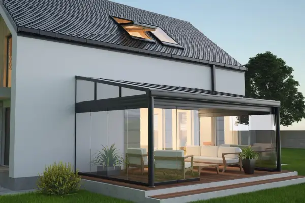 Une élégante veranda hexagonale en verre et métal, avec un salon confortable, s'intègre parfaitement à une maison moderne.