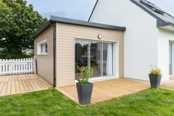 Une extension bois moderne avec terrasse en bois, créant un espace de vie extérieur agréable.