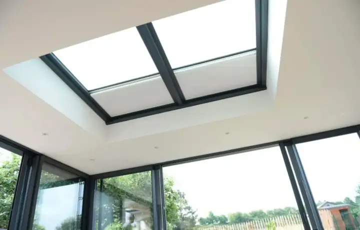 Lumière naturelle inondant une extension maison toit plat. Fenêtres panoramiques et verrière moderne.