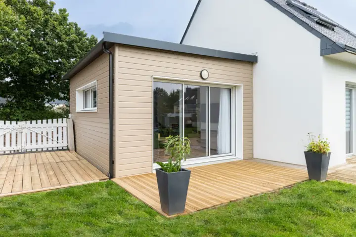 Une extension bois moderne avec terrasse en bois, créant un espace de vie extérieur agréable.